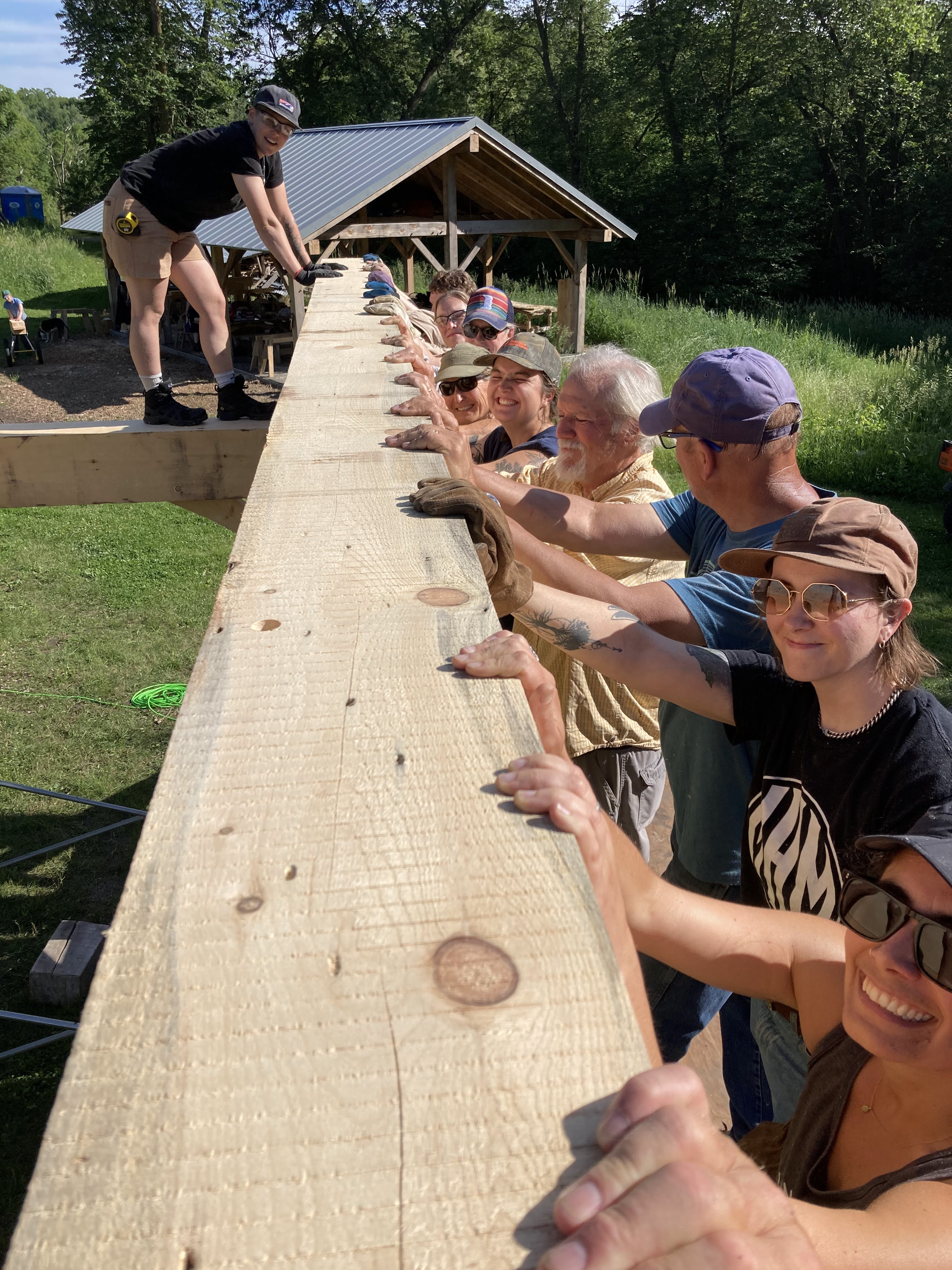 One Founder of Against The Grain - Helen Prüfer - coordinating the raising of a timber frame with a community of volunteers.