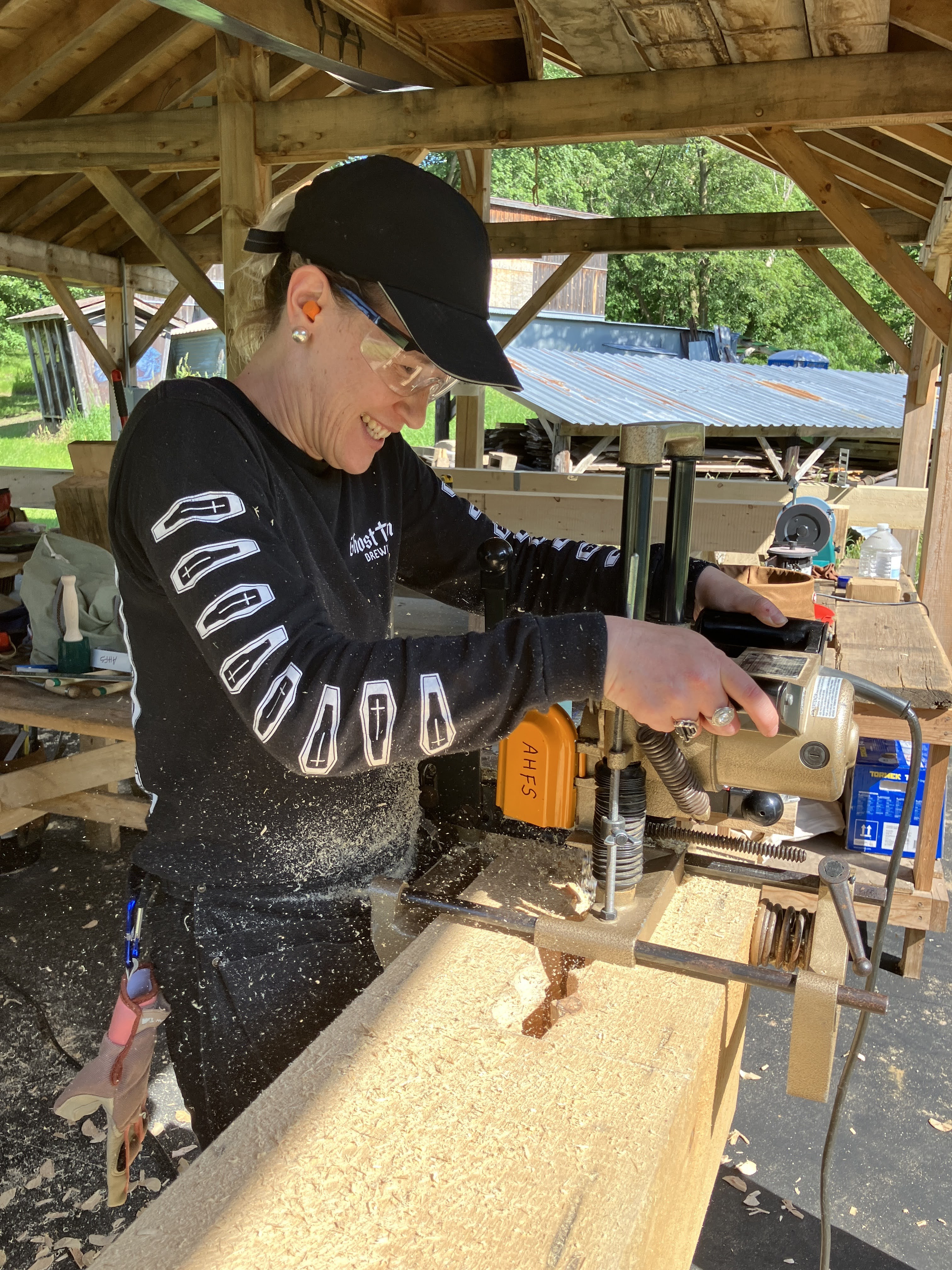 Student of a FLINTA timber framing course and now Timber Club Member, using a chain mortiser on a timber frame post.